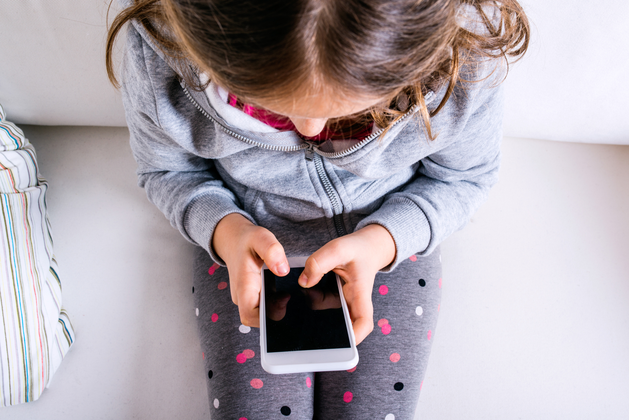 overhead view of a child working a smartphone