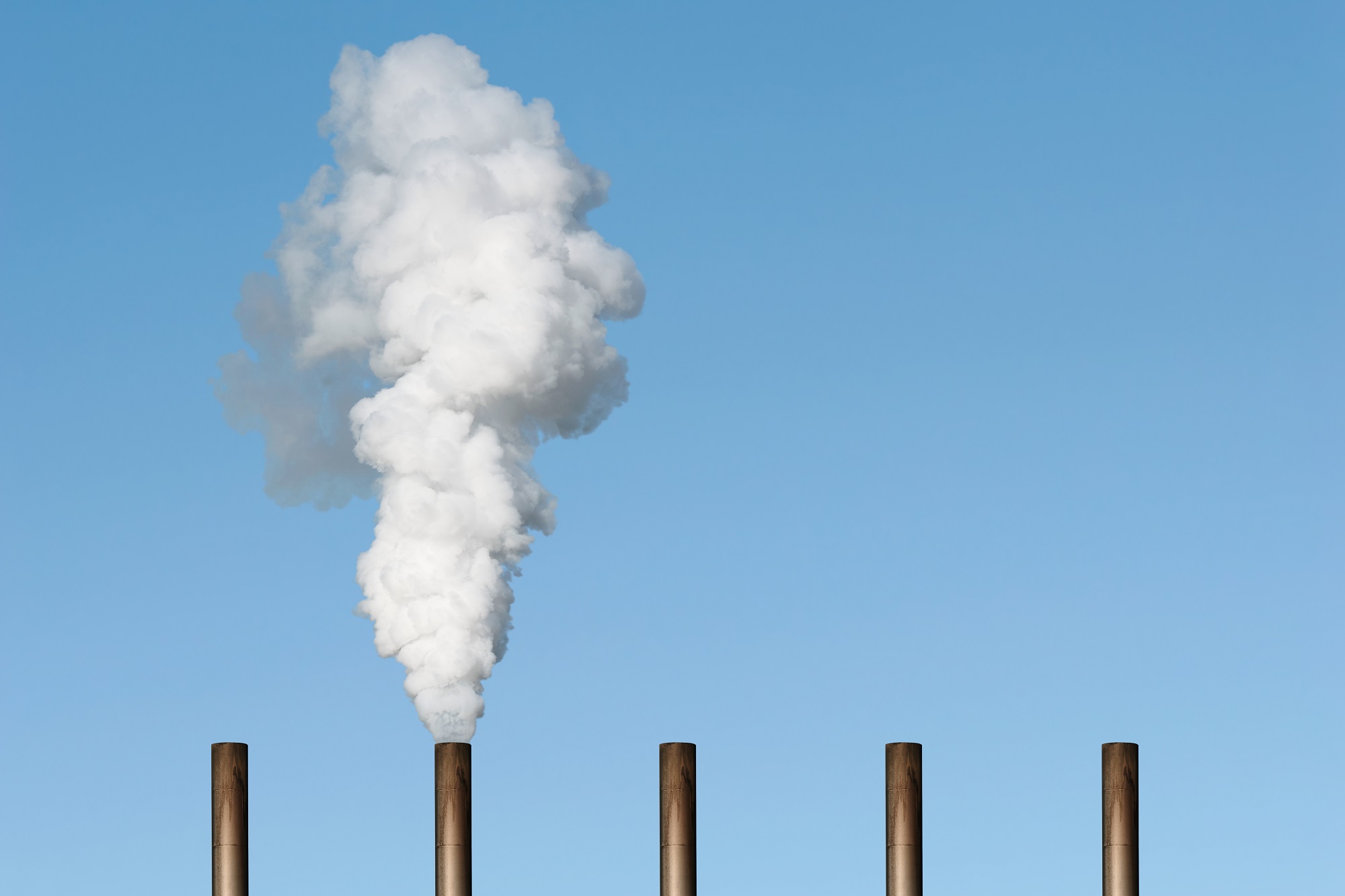 a series of chimneys with steam rising from one of them