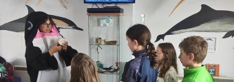 Be A Marine Biologist for a Day: Woman in a whale costume speaks to five young children